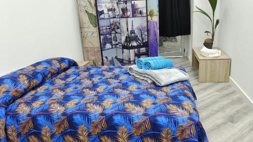 a bed with a blue comforter in a room at Lodge El Muelle Arinaga in Arinaga