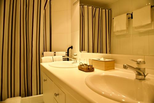 a white bathroom with a sink and a mirror at Haus Allegra Panorama in Saas-Fee