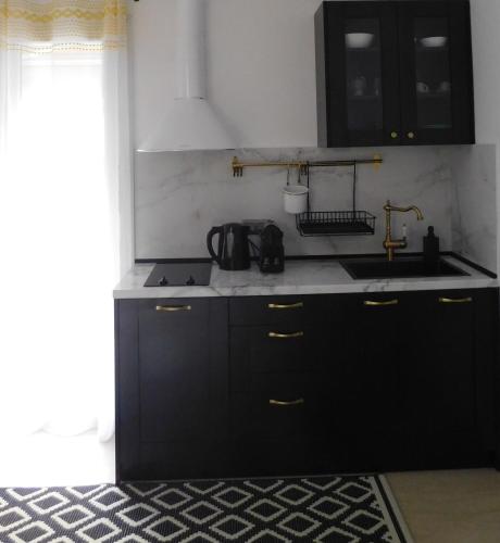 a kitchen with black cabinets and a sink at Brand New Studio 1 in Komotini
