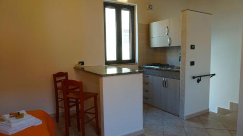 uma cozinha com um balcão e dois bancos em Porta Nuova Room Locazione Breve Turistica em Benevento