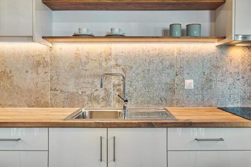 a kitchen with a sink and a dirty wall at Vera Villa - Brand New Seafront Villa! in Alykes