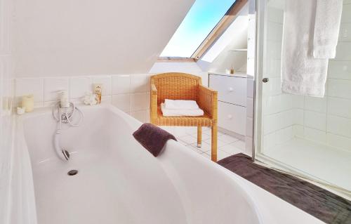 La salle de bains est pourvue d'une baignoire blanche et d'une douche. dans l'établissement Unique - villa spacieuse en front de mer - with seaview - Kermagen, à Pleubian