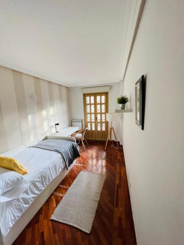 a bedroom with two beds and a wooden floor at Atico al lado del Ayuntamiento in Oviedo