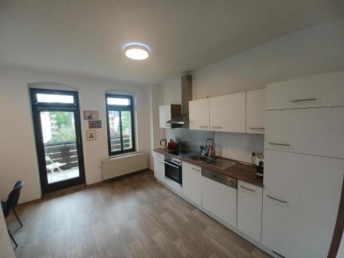 cocina con armarios blancos, fregadero y ventana en L118 Vermietungen, en Zwickau