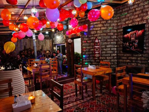 a restaurant with wooden tables and balloons hanging from the ceiling at Petra Desert Dream Hotel in Wadi Musa