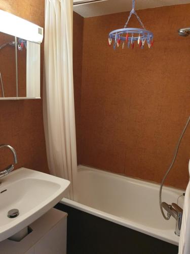 uma casa de banho com uma banheira, um lavatório e um chuveiro em Enjoy em Puy-Saint-Vincent