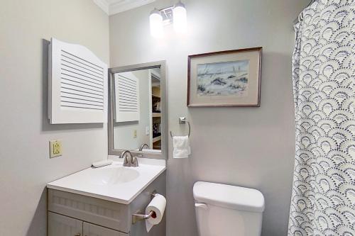 a bathroom with a sink and a toilet and a mirror at Sea Cabin 306-A in Isle of Palms
