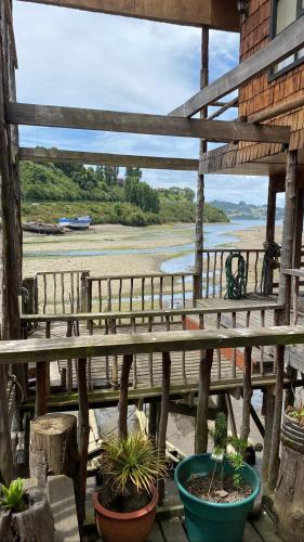 a view from the porch of a house with plants at Hostal Palafito Waiwen in Castro