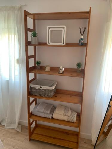 a wooden book shelf with a tv and towels at acogedor apartamento 2 dormitorios in Granada