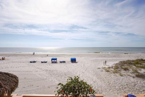 a beach with blue beach chairs and the ocean at Villa Madeira 206 in St Pete Beach