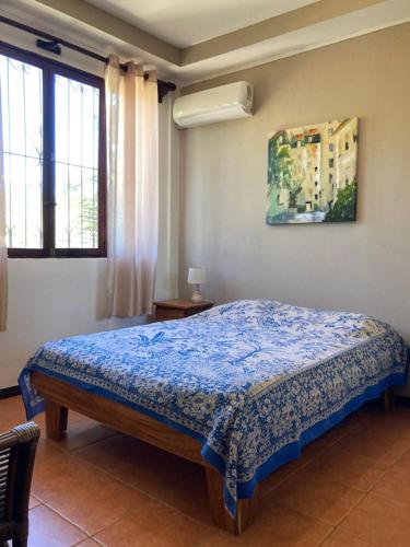 a bedroom with a bed in a room with windows at Casa Sueno Colibri in Tamarindo