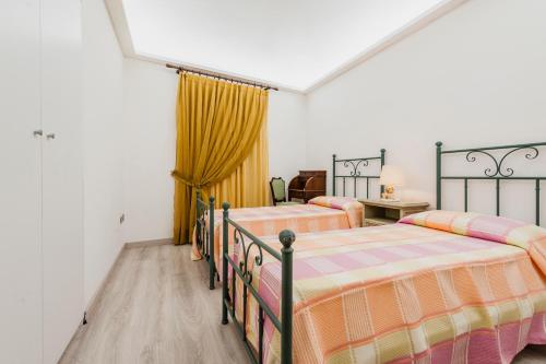 a bedroom with two beds in a room at centro, stile siciliano, balconi e terrazzino interno parcheggio Alfycodindia in Catania
