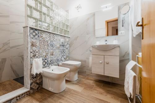 a white bathroom with a toilet and a sink at Alfycodindia in Catania