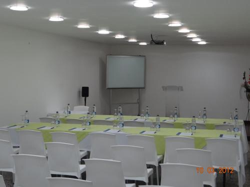 a conference room with a table and white chairs at Hotel Kamani Florencia in Florencia