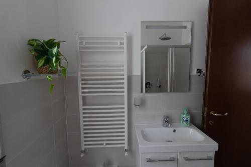 a white bathroom with a sink and a mirror at Casa Pietro e Bea in Rapallo