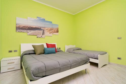 a bedroom with two beds with green walls at Il Ciclamino in Tarquinia