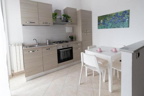 cocina con mesa, mesa blanca y sillas en Casa Pietro e Bea, en Rapallo