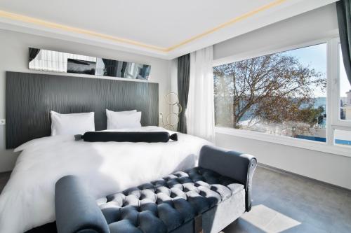 Via Çırağan Hotel في إسطنبول: غرفة نوم بسرير كبير ونافذة كبيرة