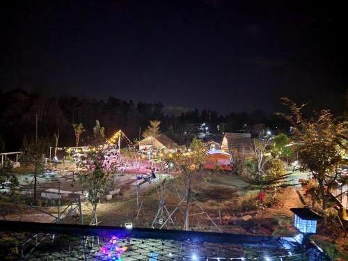 a park lit up at night with christmas lights at บ้าน วังน้ำเขียว in Ban Kom