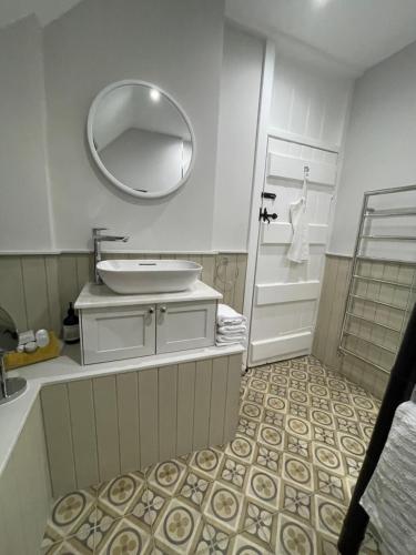 a bathroom with a sink and a mirror at BEECH COTTAGE in Hatherop