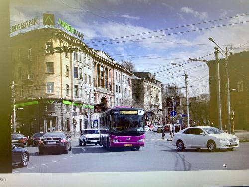 een paarse bus rijdt door een straat met auto's bij Apartment in Yerevan Moskovyan in Jerevan