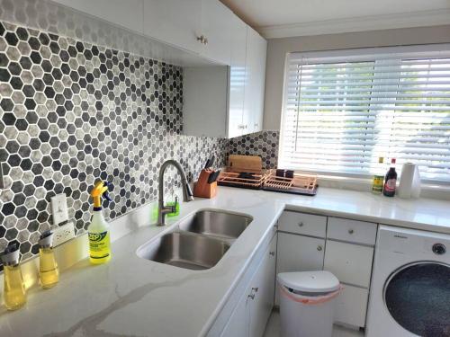 uma cozinha com um lavatório e uma bancada em Modern Luxury 2-bedroom 2.5-bathroom townhouse em Negril