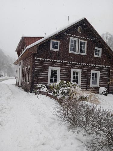 a house covered in snow in front at Pension Slunečnice in Pec pod Sněžkou