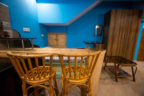 Habitación azul con mesa de madera y sillas en Godwill Casa Varca en Varca