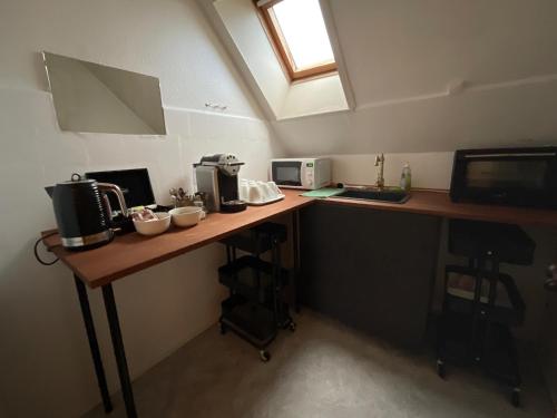 a kitchen with a counter with a sink and a microwave at Otel Vaabensted in Sakskøbing