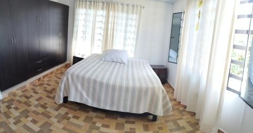 een slaapkamer met een bed met een gestreepte deken bij Casa Azul Pinar del Rio San Agustín in San Agustín
