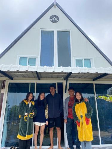 a group of people standing in front of a house at อุ่นฟ้าอิงดาว A-frame 2 in Ban Kom