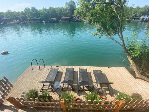 eine Gruppe von Stühlen auf einem Dock im Wasser in der Unterkunft Mery Ada House in Ulcinj