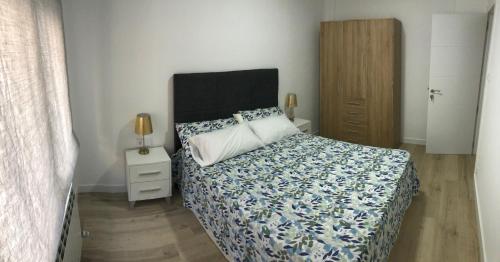 1 dormitorio con 1 cama con edredón azul y blanco en PARQUE DE LA MARINA ESPAÑOLA, en Zamora