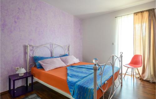 Vinež的住宿－Nice Home In Labin With Jacuzzi，一间卧室配有一张带橙色和蓝色毯子的床