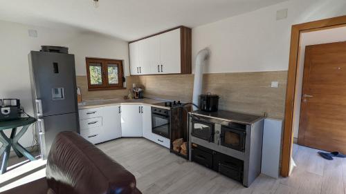 a kitchen with a stove and a refrigerator at Vikendica Pašter in Šipovo