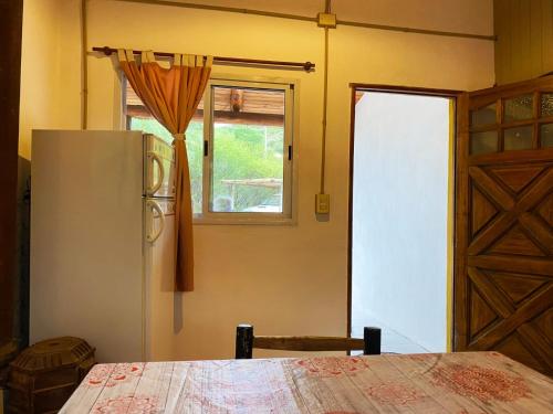 uma cozinha com um frigorífico, uma janela e uma porta em Casita Libertad en San Marcos em San Marcos Sierras