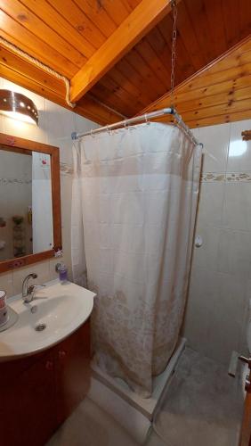 a bathroom with a shower curtain and a sink at Happiness Zimmer צימר האושר - גם לציבור הדתי in Nahariyya