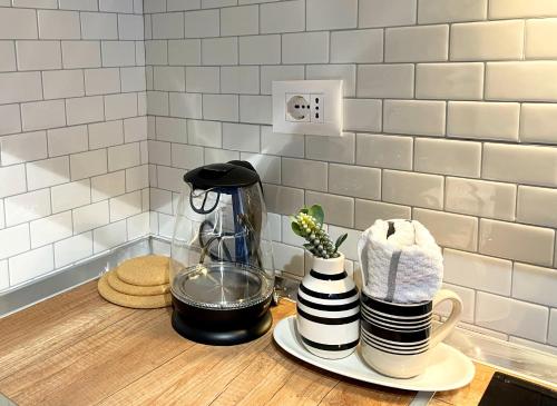 a kitchen counter with a coffee maker and a stack of dishes at Foleza e Pazarit in Korçë
