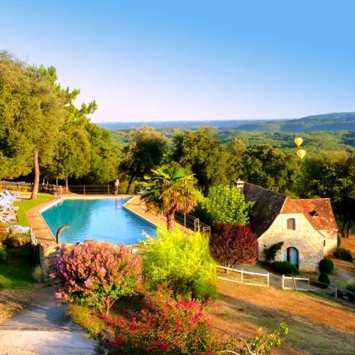 une piscine dans une cour à côté d'une maison dans l'établissement Eco-hameau Du Sentier Des Sources, à Sarlat-la-Canéda