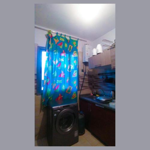 a kitchen with a shower curtain and a washing machine at Appartement au calme hors du bruit de Casablanca à Bouskoura in Bouskoura