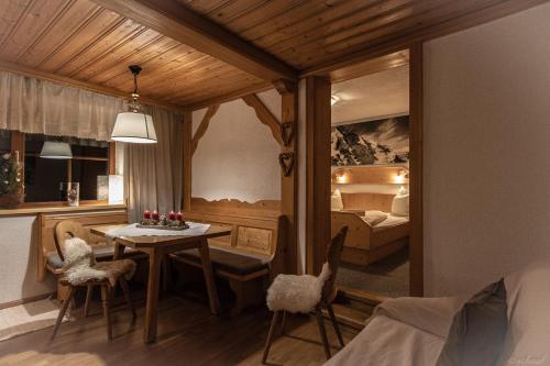 a room with a table and a bed and a bedroom at Bauernhof Stempf - Appartement "HOCHARN" in Heiligenblut