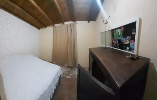 1 dormitorio con 1 cama y TV. en Alojamiento temporario Galo 1 en Mar del Plata