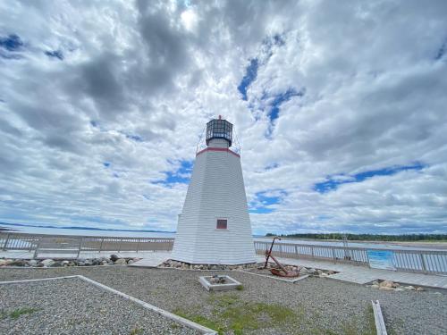 a lighthouse sitting on the side of a body of water at Captain Dan's Shanty in Saint Andrews