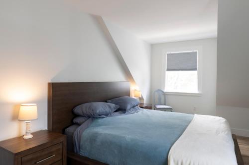 a bedroom with a bed with blue sheets and a window at Captain Dan's Shanty in Saint Andrews