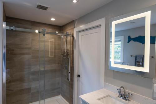 a bathroom with a shower and a sink and a mirror at Captain Dan's Shanty in Saint Andrews