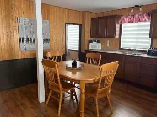 a kitchen with a wooden table with a cat sitting on it at La Cabane chez Jimmy in Petit-Saguenay