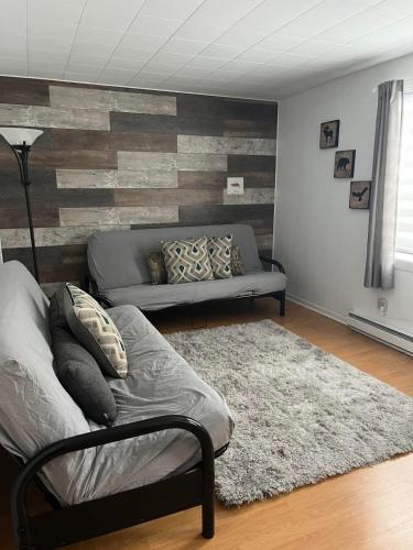 a living room with a couch and a rug at La Cabane chez Jimmy in Petit-Saguenay