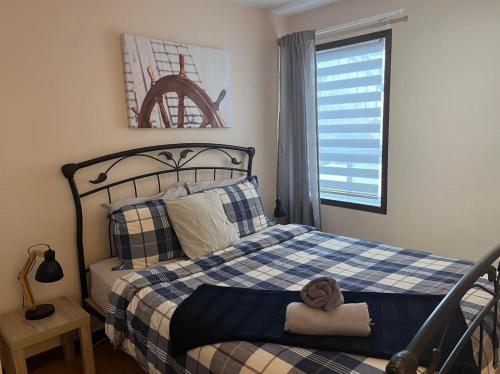 a bedroom with a bed with a blue and white plaid at La Cabane chez Jimmy in Petit-Saguenay
