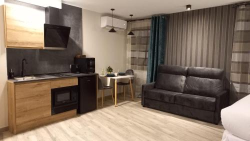 a kitchen and a living room with a couch and a table at Airen Suites in Chinchón