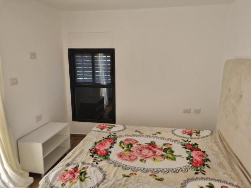 a bedroom with a bed with flowers on it at האשוח in Ashkelon